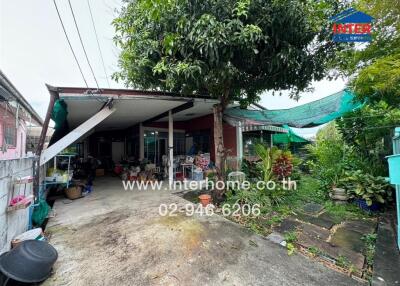 Exterior view of a property with an open garage and garden area