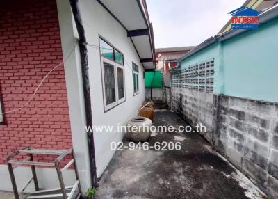 Side view of a house with a brick and concrete wall