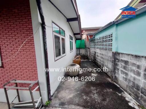 Side view of a house with a brick and concrete wall