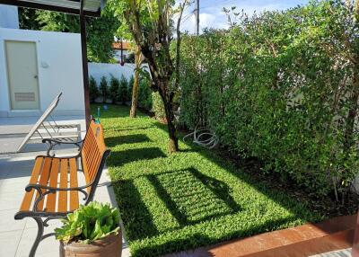 Well-maintained garden with a bench and lush greenery