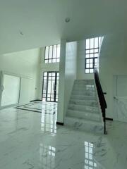 Spacious main living area with large windows and marble stairs