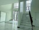 Spacious main living area with large windows and marble stairs