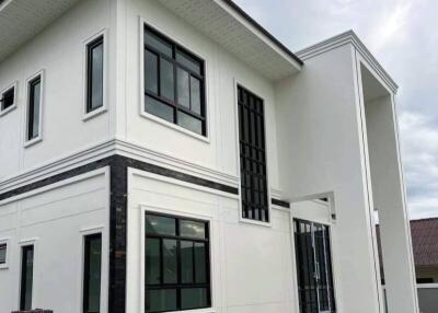 Modern white two-story house with large windows