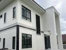 Modern white two-story house with large windows