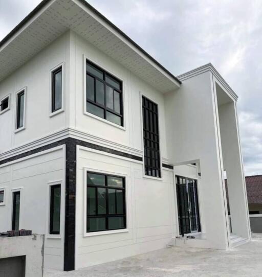 Modern white two-story house with large windows