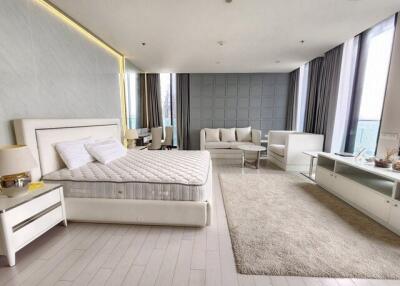 Spacious bedroom with seating area and modern furnishings