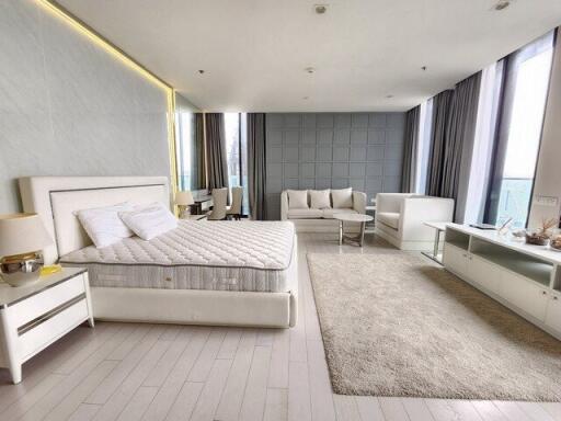 Spacious bedroom with seating area and modern furnishings