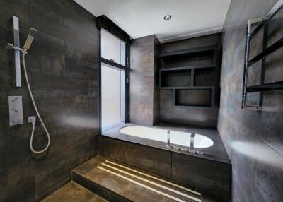 Modern bathroom with dark tiles and built-in bathtub