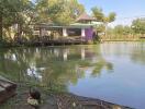 A house overlooking a small pond with lush greenery