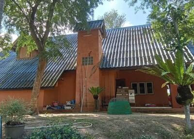 Exterior view of a house with sloped roof and a central chimney