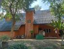 Exterior view of a house with sloped roof and a central chimney