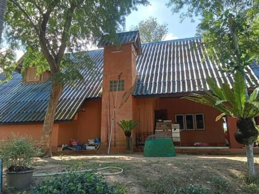 Exterior view of a house with sloped roof and a central chimney