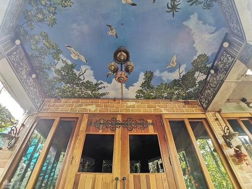 Outdoor area with artistic ceiling and wooden doors