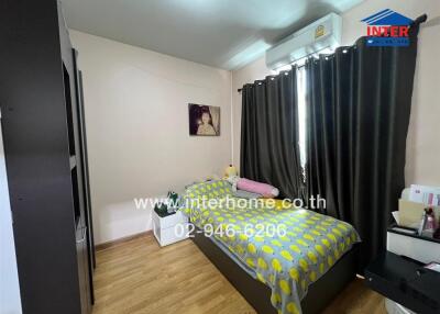 Cozy bedroom with wooden flooring, a single bed, and a wall-mounted air conditioner