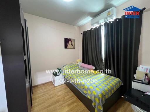 Cozy bedroom with wooden flooring, a single bed, and a wall-mounted air conditioner