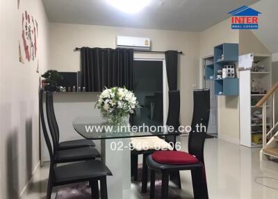 Modern dining area with black chairs and a centerpiece flower arrangement