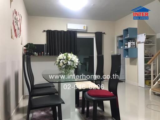 Modern dining area with black chairs and a centerpiece flower arrangement