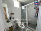 Modern bathroom with glass shower and white tiles