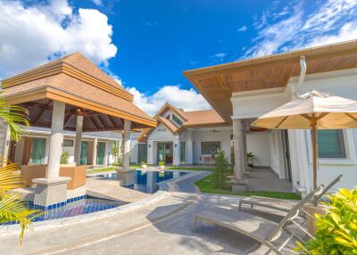 Exterior view of a modern house with a pool and seating area