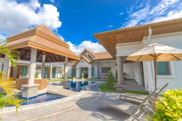 Exterior view of a modern house with a pool and seating area