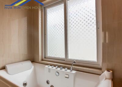 Bathroom with jacuzzi bathtub and frosted windows