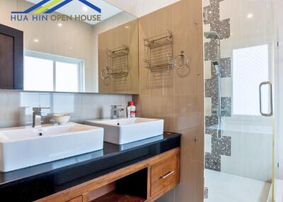 Modern bathroom with dual sinks and glass-enclosed shower