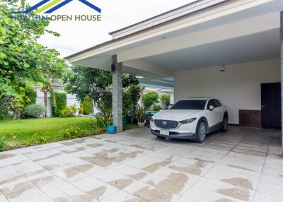 Covered garage with a parked car