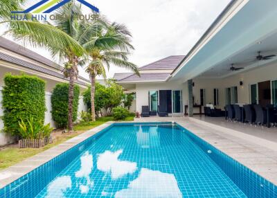 Outdoor swimming pool area with seating and palm trees