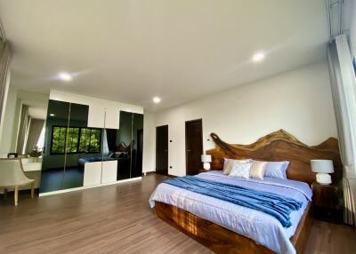 Spacious and modern bedroom with wooden accents and large mirrored closet