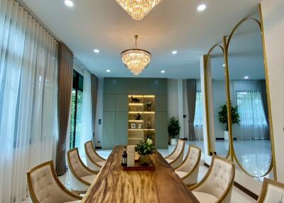 Dining room with large wooden table and modern chandeliers