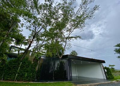 Modern house exterior with garage and tall trees