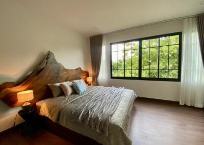 Spacious bedroom with large window and wooden flooring