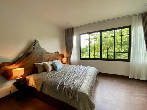 Spacious bedroom with large window and wooden flooring