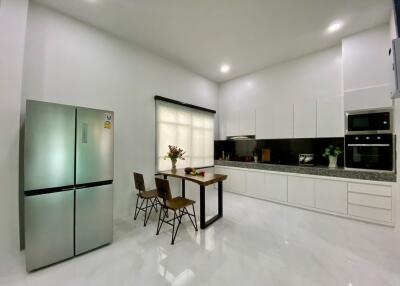 Modern kitchen with white cabinetry and dining area