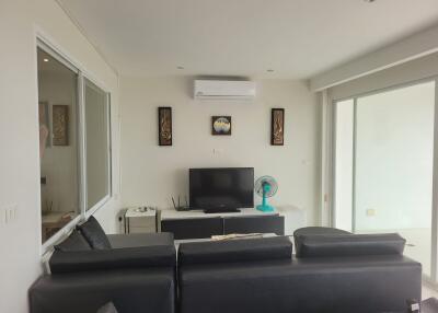 Living room with a sofa, TV, air conditioner, and decorative wall art