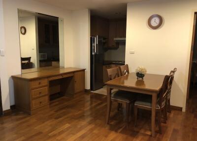 Dining area with wooden furniture and kitchen entrance