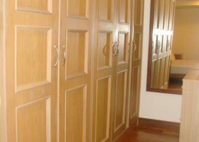 Bedroom with wooden wardrobes and wooden flooring