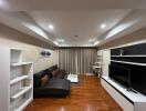 Modern living room with brown parquet floor, sectional leather sofa, TV unit, and sleek shelving