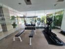 Modern gym room with exercise equipment and view of swimming pool