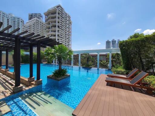 Outdoor swimming pool with deck chairs and pergola