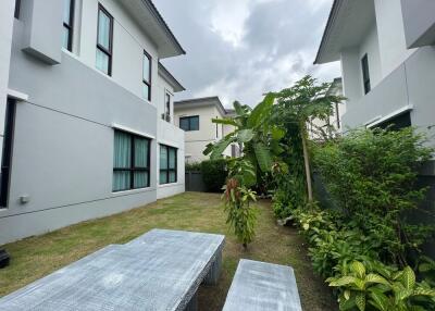 Garden view with outdoor seating area and surrounding buildings