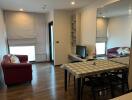 Modern living room with dining area, red sofas, and large mirrored wall