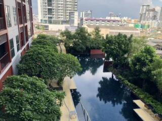 View of swimming pool and garden area with cityscape in the background