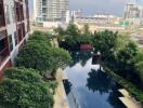 View of swimming pool and garden area with cityscape in the background