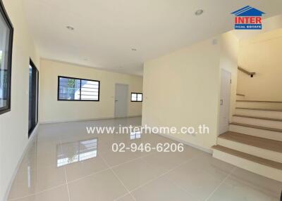 Spacious modern living area with tiled flooring and staircase