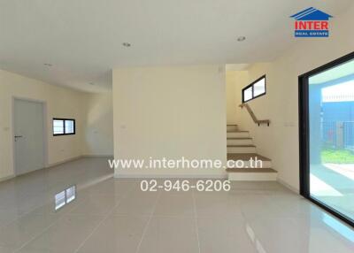 Spacious living area with staircase and large windows