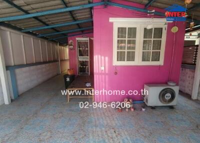 Covered outdoor area with vibrant pink wall