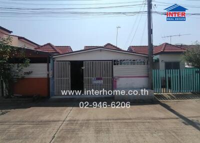 Front view of a residential property with gated entrance and driveway