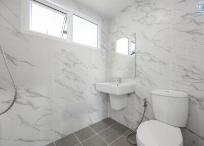 Modern bathroom with white marble tiles and fixtures