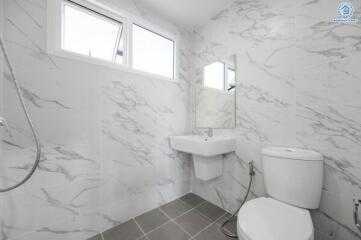 Modern bathroom with white marble tiles and fixtures